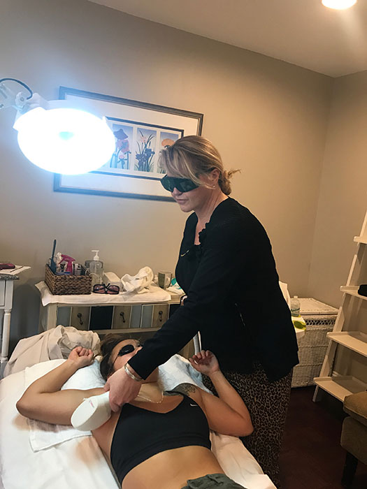 A woman having laser hair removal on her underarms.